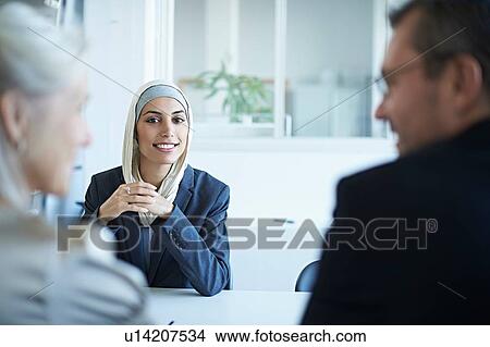 Over shoulder view of young businesswoman at interview in office View Large Photo Image Picture - Over shoulder view of young businesswoman at interview in office. Fotosearch