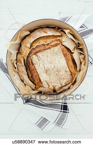 Stock Photo - Overhead view of artisan sourdough bread in saucepan. Fotosearch