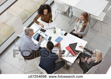 Overhead view of business team meeting at conference table View Large Photo Image Stock Photo - Overhead view of business team meeting at conference table. Fotosearch