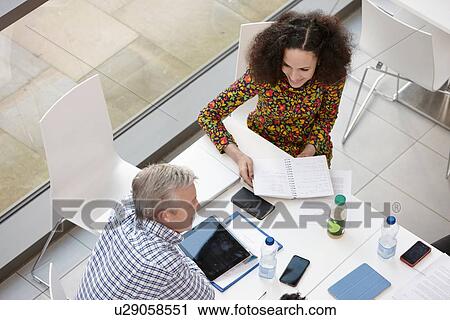 Overhead view of businessman and woman meeting at conference table View Large Photo Image Stock Image - Overhead view of businessman and woman meeting at conference table. Fotosearch