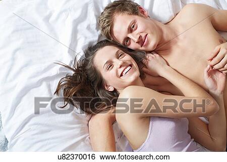 Overhead view of young couple on bed View Large Photo Image Stock Photograph - Overhead view of young couple on bed. Fotosearch