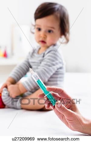 Paediatrician about to give baby boy an injection View Large Photo Image Stock Photo - Paediatrician about to give baby boy an injection. Fotosearch