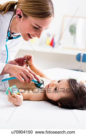 Stock Image - Paediatrician checking baby boy's heart using stethoscope. Fotosearch