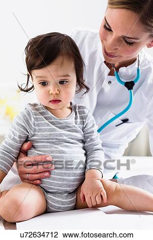 Stock Image - Paediatrician doing assessment of baby boy. Fotosearch