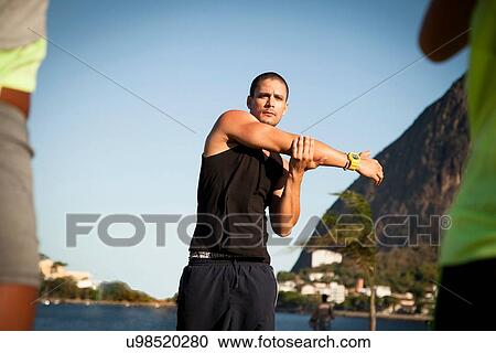 Personal trainer demonstrating stretch exercise in park View Large Photo Image Stock Image - Personal trainer demonstrating stretch exercise in park. Fotosearch