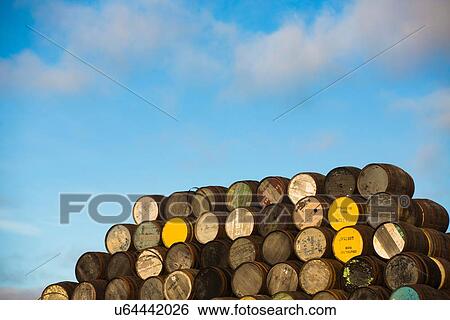 Stock Photograph - Pile of wooden whisky casks outside. Fotosearch