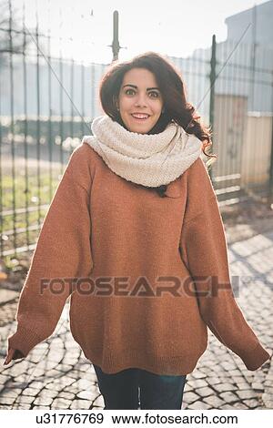 Stock Photo - Portrait of beautiful young woman posing in park. Fotosearch