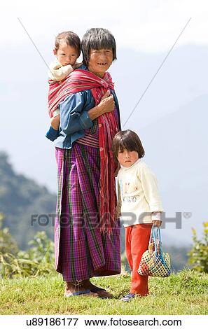 Stock Photo - "Portrait of Bhutanese woman and two children on hill, Timpu, Bhutan". Fotosearch