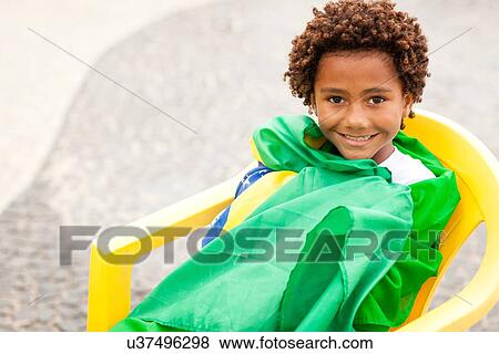 "Portrait of boy wrapped up in Brazilian flag sitting on Ipanema beach, Rio De Janeiro, Brazil" View Large Photo Image Stock Photo - "Portrait of boy wrapped up in Brazilian flag sitting on Ipanema beach, Rio De Janeiro, Brazil". Fotosearch