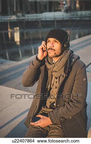 Picture - Portrait of businessman listening to headphones. Fotosearch