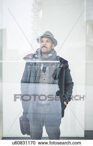 Portrait of businessman with hands in pockets behind window View Large Photo Image Stock Image - Portrait of businessman with hands in pockets behind window. Fotosearch