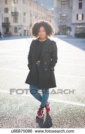 Portrait of confident stylish young woman in town square View Large Photo Image Stock Photograph - Portrait of confident stylish young woman in town square. Fotosearch