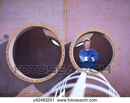 Portrait of engineer inside large steel superstructure in engineering factory View Large Photo Image Stock Image - Portrait of engineer inside large steel superstructure in engineering factory. Fotosearch