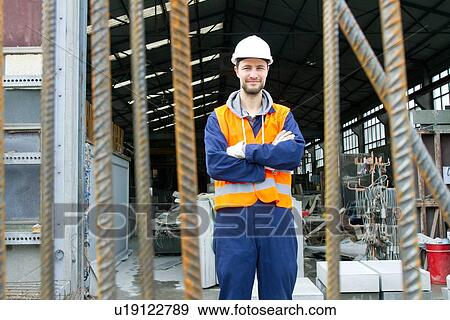 Stock Photo - Portrait of factory worker outside concrete reinforcement factory. Fotosearch