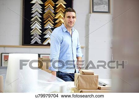 Picture - Portrait of framer in picture framers workshop. Fotosearch