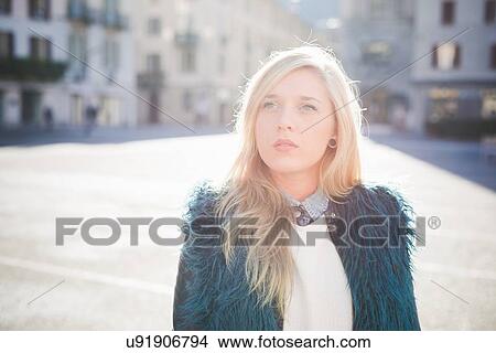 Portrait of funky young woman wearing furry jacket in town square View Large Photo Image Picture - Portrait of funky young woman wearing furry jacket in town square. Fotosearch