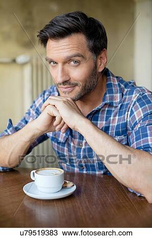 Stock Image - Portrait of handsome mature man in cafe. Fotosearch