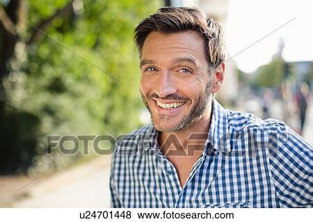 Stock Photo - Portrait of handsome smiling mature man on street. Fotosearch