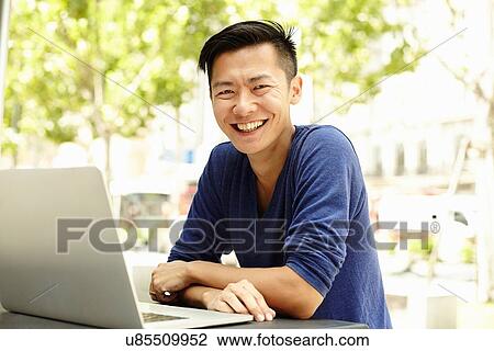 "Portrait of male tourist using laptop at sidewalk cafe, The Bund, Shanghai, China" View Large Photo Image Stock Image - "Portrait of male tourist using laptop at sidewalk cafe, The Bund, Shanghai, China". Fotosearch