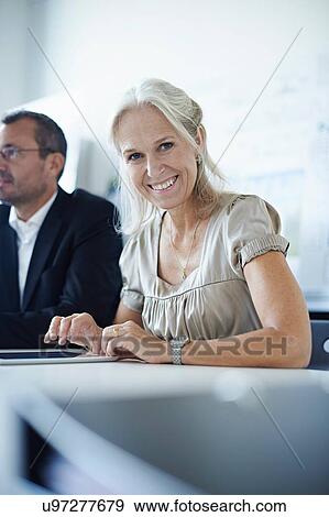 Portrait of mature businesswoman in office meeting View Large Photo Image Stock Photo - Portrait of mature businesswoman in office meeting. Fotosearch