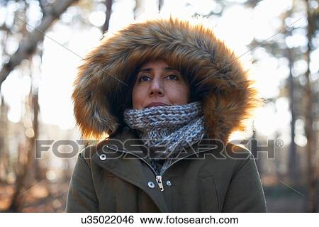 Portrait of mature woman wearing fur hood and scarf in forest View Large Photo Image Stock Photograph - Portrait of mature woman wearing fur hood and scarf in forest. Fotosearch