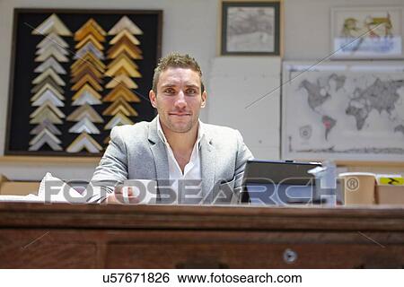 Portrait of mid adult man at desk in picture framers workshop View Large Photo Image Stock Photograph - Portrait of mid adult man at desk in picture framers workshop. Fotosearch