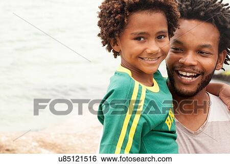 "Portrait of mid adult man carrying son on Ipanema Beach, Rio De Janeiro, Brazil" View Large Photo Image Stock Photograph - "Portrait of mid adult man carrying son on Ipanema Beach, Rio De Janeiro, Brazil". Fotosearch