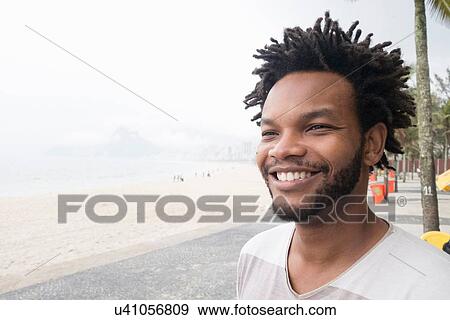 Stock Photo - "Portrait of mid adult man on Ipanema beach, Rio De Janeiro, Brazil". Fotosearch