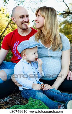 "Portrait of mother, father and son sitting together, outdoors, in rural setting" View Large Photo Image Stock Image - "Portrait of mother, father and son sitting together, outdoors, in rural setting". Fotosearch