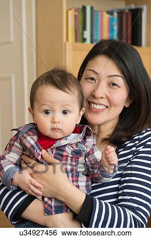 Stock Photograph - "Portrait of mother holding son, smiling". Fotosearch