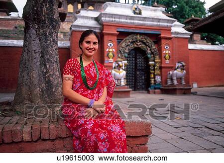 Stock Image - "Portrait of Nepalese woman sitting outside temple, Kathmandu, Nepal". Fotosearch