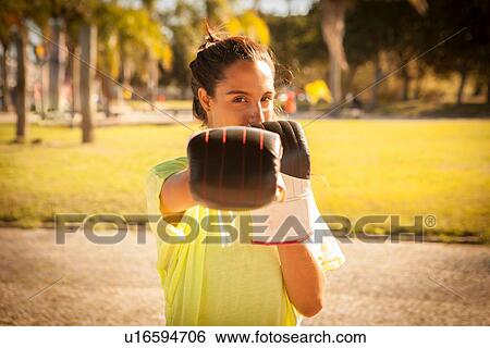 Stock Photograph - Portrait of poised female boxer in park. Fotosearch
