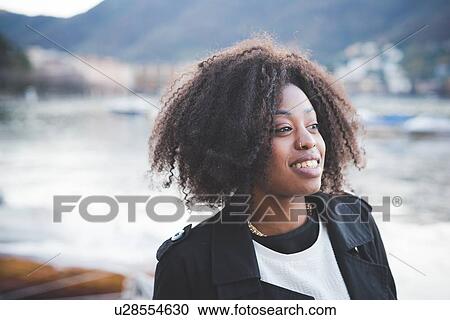 Stock Image - "Portrait of smiling young woman at Lake Como, Como, Italy". Fotosearch