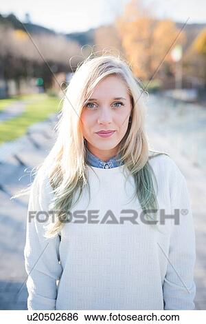 Portrait of smiling young woman in park View Large Photo Image Stock Photograph - Portrait of smiling young woman in park. Fotosearch