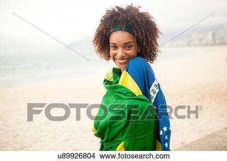 "Portrait of smiling young woman wrapped in Brazilian flag on Ipanema beach, Rio De Janeiro, Brazil" View Large Photo Image Picture - "Portrait of smiling young woman wrapped in Brazilian flag on Ipanema beach, Rio De Janeiro, Brazil". Fotosearch