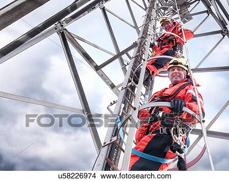 "Portrait of tower workers climbing radio tower on offshore windfarm, low angle view" View Large Photo Image Picture - "Portrait of tower workers climbing radio tower on offshore windfarm, low angle view". Fotosearch