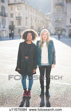 Picture - Portrait of two cool female friends in town square. Fotosearch