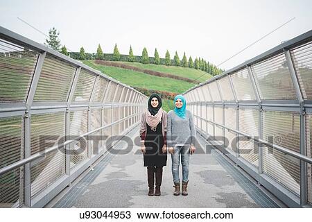 Portrait of two young female friends on park footbridge View Large Photo Image Stock Image - Portrait of two young female friends on park footbridge. Fotosearch