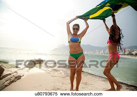 "Portrait of two young women dancing whilst holding up Brazilian flag, Ipanema beach, Rio De Janeiro, Brazil" View Large Photo Image Stock Photography - "Portrait of two young women dancing whilst holding up Brazilian flag, Ipanema beach, Rio De Janeiro, Brazil". Fotosearch