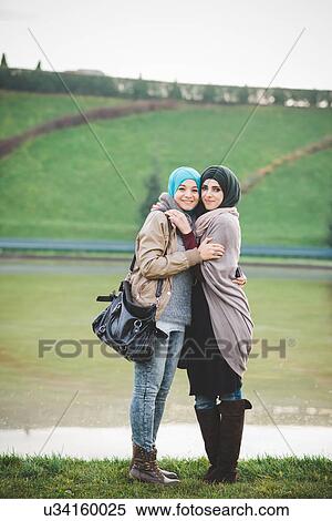 Portrait of two young women hugging on lakeside View Large Photo Image Stock Photography - Portrait of two young women hugging on lakeside. Fotosearch