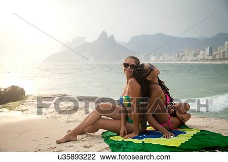"Portrait of two young women sitting on Brazilian flag, Ipanema beach, Rio De Janeiro, Brazil" View Large Photo Image Stock Image - "Portrait of two young women sitting on Brazilian flag, Ipanema beach, Rio De Janeiro, Brazil". Fotosearch