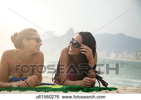"Portrait of two young women sunbathing on Brazilian flag, Ipanema beach, Rio De Janeiro, Brazil" View Large Photo Image Stock Photograph - "Portrait of two young women sunbathing on Brazilian flag, Ipanema beach, Rio De Janeiro, Brazil". Fotosearch