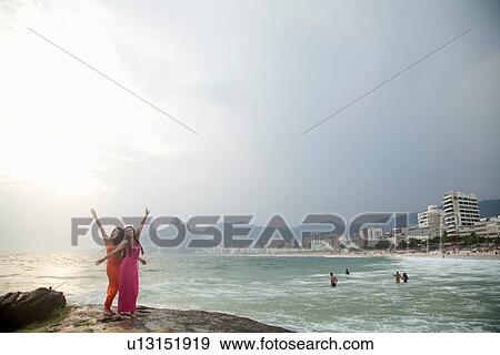 "Portrait of two young women with arms raised on Ipanema beach, Rio De Janeiro, Brazil" View Large Photo Image Stock Photo - "Portrait of two young women with arms raised on Ipanema beach, Rio De Janeiro, Brazil". Fotosearch