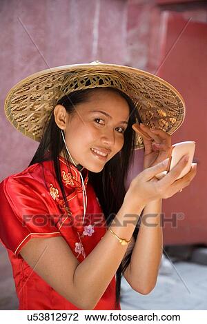 Stock Image - "Portrait of woman in chinese dress, putting on make up, Beijing, China". Fotosearch