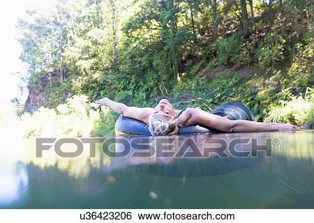"Portrait of woman lying on rubber ring in river, Coromandel Peninsula, North Island, New Zealand" View Large Photo Image Stock Photograph - "Portrait of woman lying on rubber ring in river, Coromandel Peninsula, North Island, New Zealand". Fotosearch