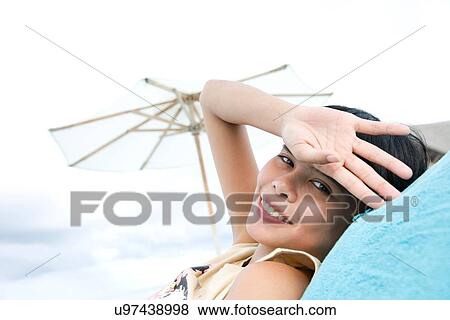 Stock Photo - "Portrait of woman relaxing on beach, Ari Atoll, Maldives". Fotosearch