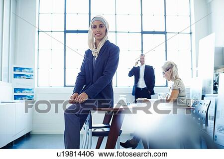 Portrait of young businesswoman sitting on office desk View Large Photo Image Stock Photograph - Portrait of young businesswoman sitting on office desk. Fotosearch