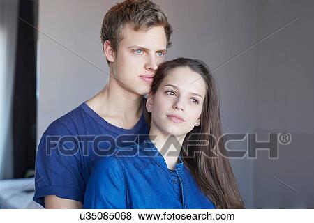 Stock Photo - Portrait of young couple in room gazing. Fotosearch