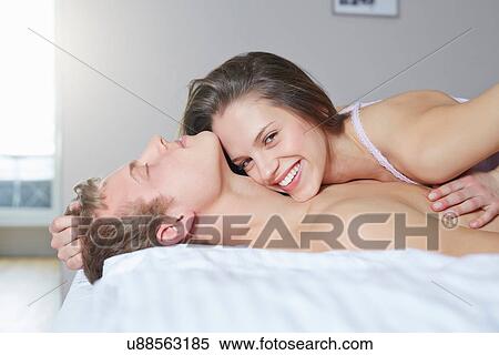 Stock Photography - Portrait of young couple on bed. Fotosearch