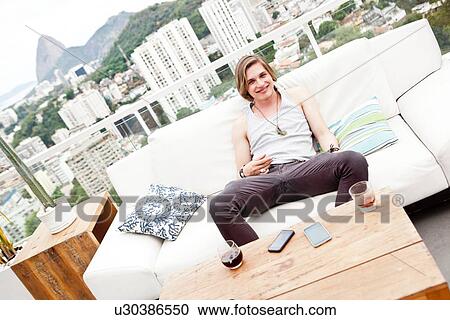 "Portrait of young man on rooftop terrace sofa, Rio De Janeiro, Brazil" View Large Photo Image Stock Image - "Portrait of young man on rooftop terrace sofa, Rio De Janeiro, Brazil". Fotosearch
